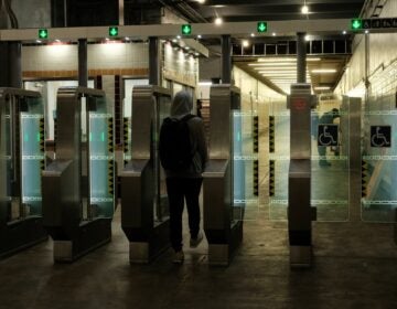 a SEPTA rider walks through the full-length fare gates