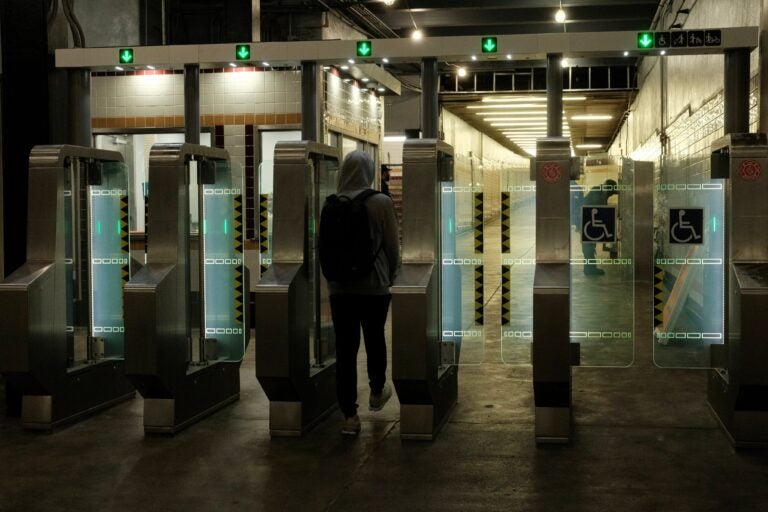 a SEPTA rider walks through the full-length fare gates