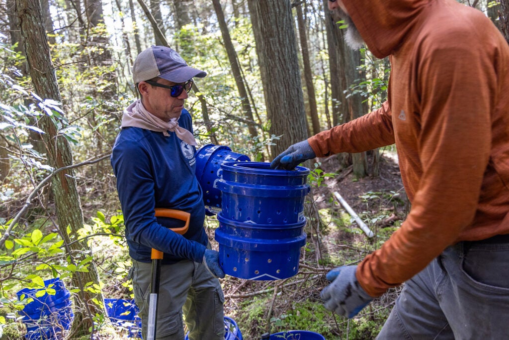 Joshua Moody, a researcher at the NJDEP Division of Science and Research, holds a blue container