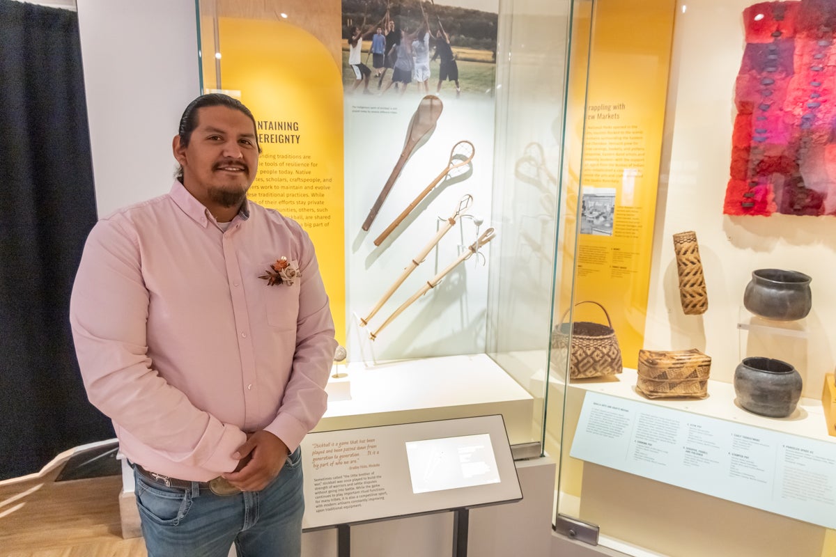 Bradley Hicks stands with his artwork at Penn Museum