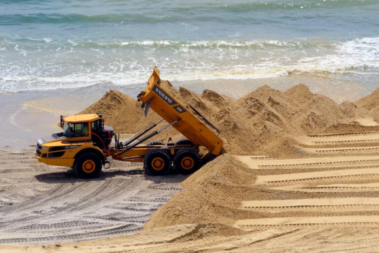 Sand dunes on the beach and a work vehicle