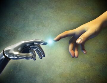Human hand touching an android hand. (Bigstock)