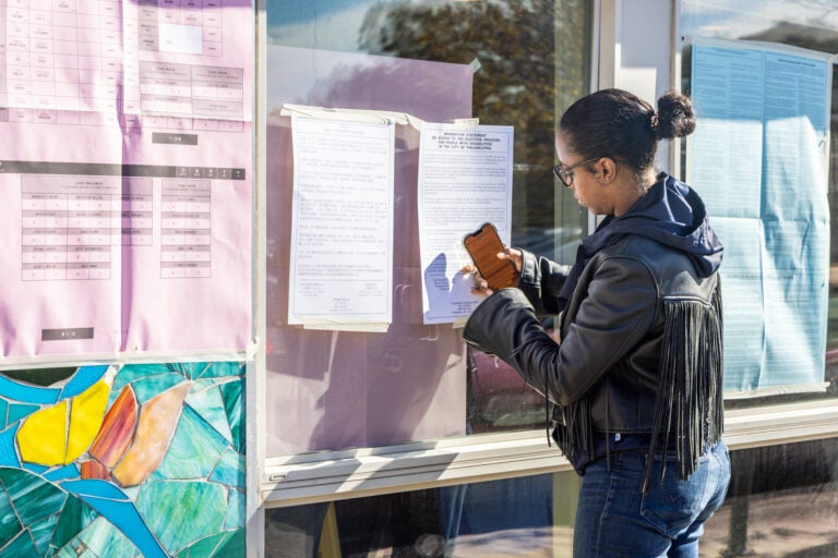 Democratic committee person Nicole Moy fixes a sign outside a South Kensington polling place
