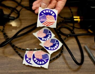 An election worker offers stickers to voters at the Moorestown Township Fire Station.