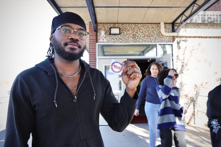 Willingboro resident Hezekiah Sara shows off his viting sticker after casting his ballot at Stuart Elementary School.