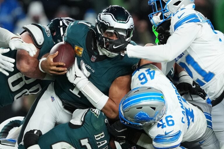 Philadelphia Eagles quarterback Jalen Hurts (1) is stopped with the ball during the second half of an NFL football game by Detroit Lions linebacker Jack Campbell (46) and Lions cornerback Amik Robertson (21) Sunday, Nov. 16, 2025, in Philadelphia.