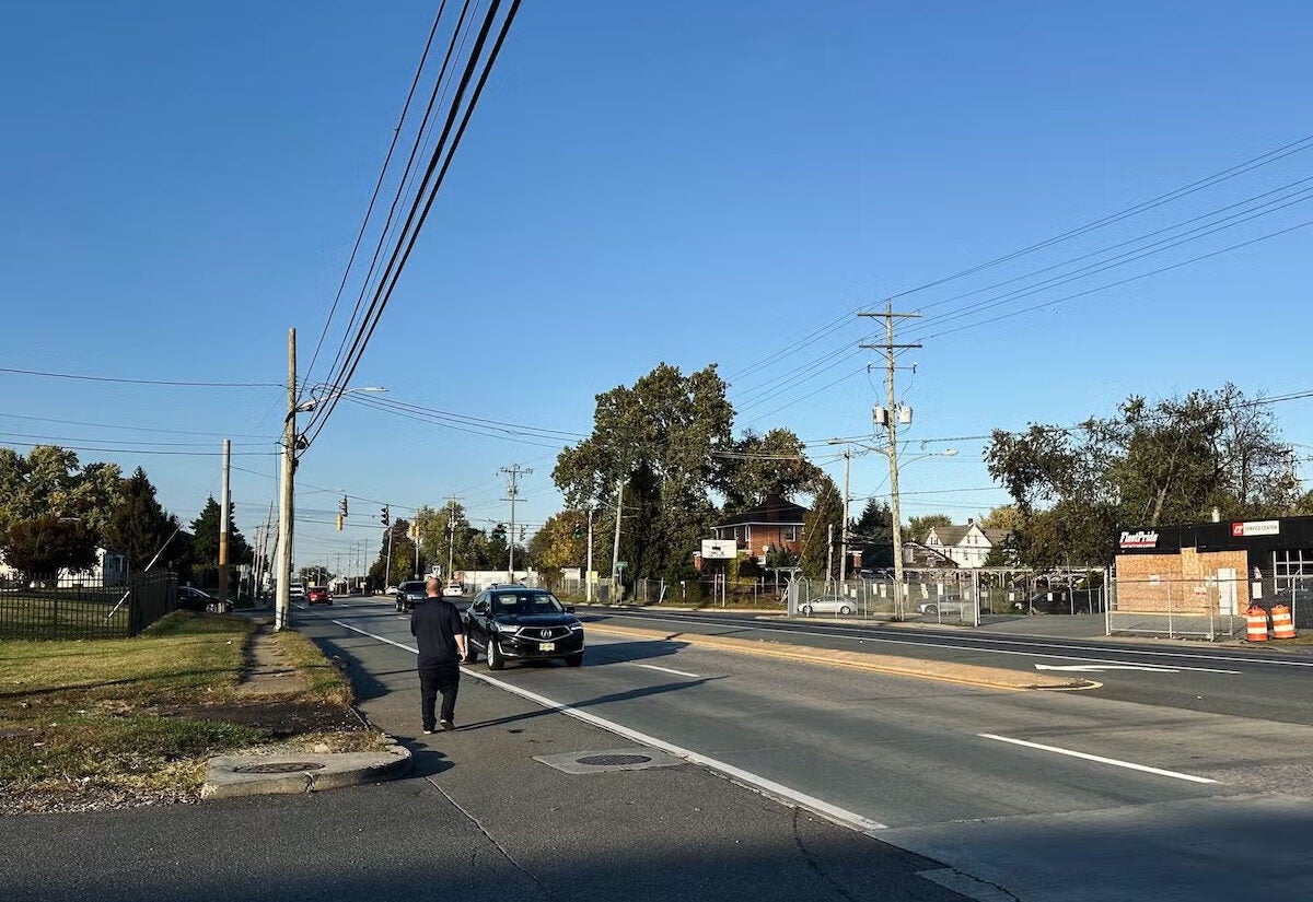 Un hombre intenta cruzar la concurrida autopista Ruta 9, un tramo conocido por su elevado número de atropellos mortales. En la intersección con Lambson Lane, los investigadores han recomendado la construcción de un puente peatonal para mejorar la seguridad. (Johnny Perez-Gonzalez/WHYY)