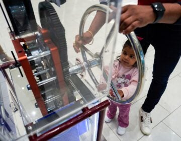 Death of the Penny A girl and a parent use a penny press machine