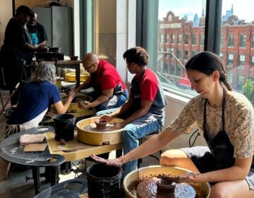 Participants learning clay techniques on pottery wheels