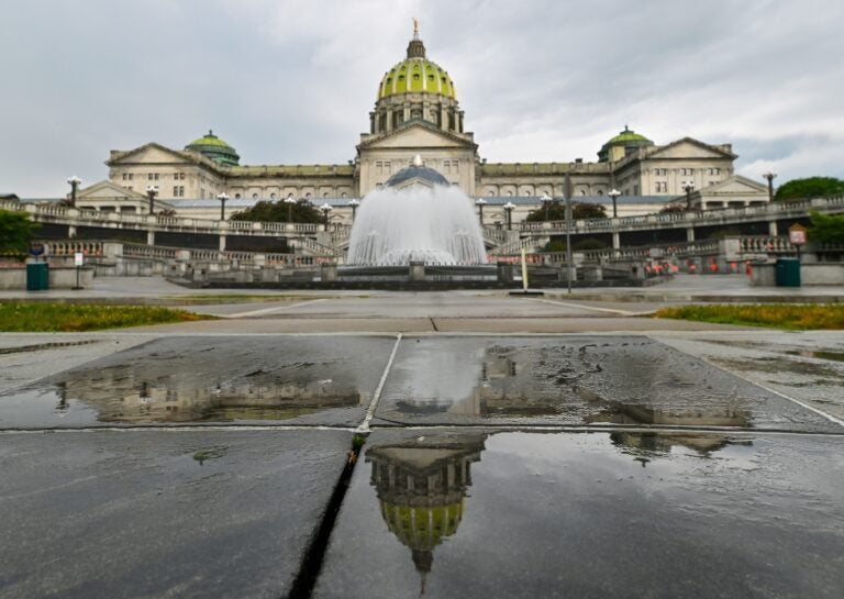 The Pennsylvania State Capitol is reflected on the ground