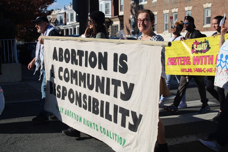 People hold up a sign that reads 