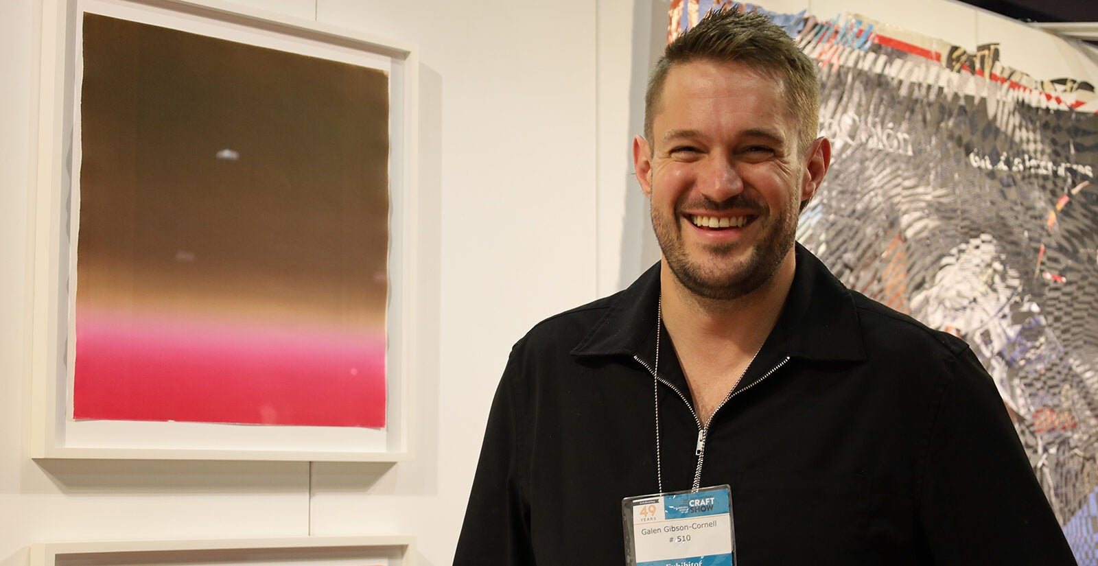 Galen Gibson-Cornell stands in front of one of his art pieces