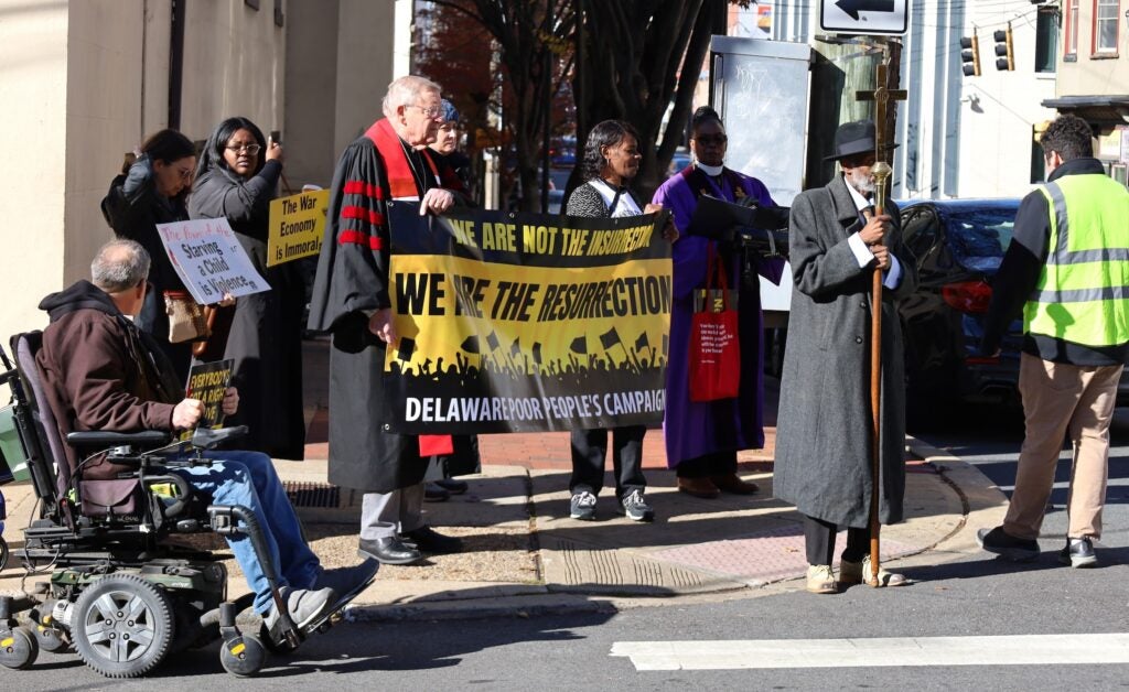 People marching on the sidewalk and holding up signs