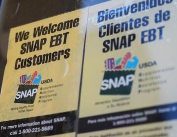 A sign with SNAP EBT information is posted on a store window