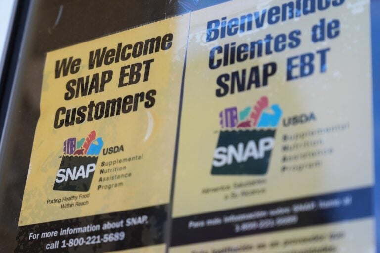 A sign with SNAP EBT information is posted on a store window