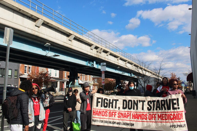 People hold up a sign that reads 