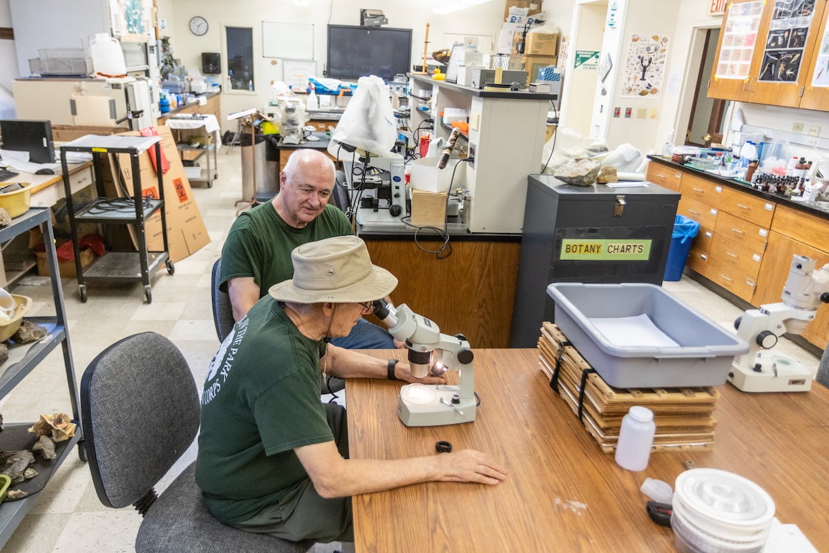Inside a biology lab at Chestnut Hill College in Philadelphia, Bob Meyer looks on as David Schogel looks into a microscope, examining a sample of water taken from the Wissahickon Creek.