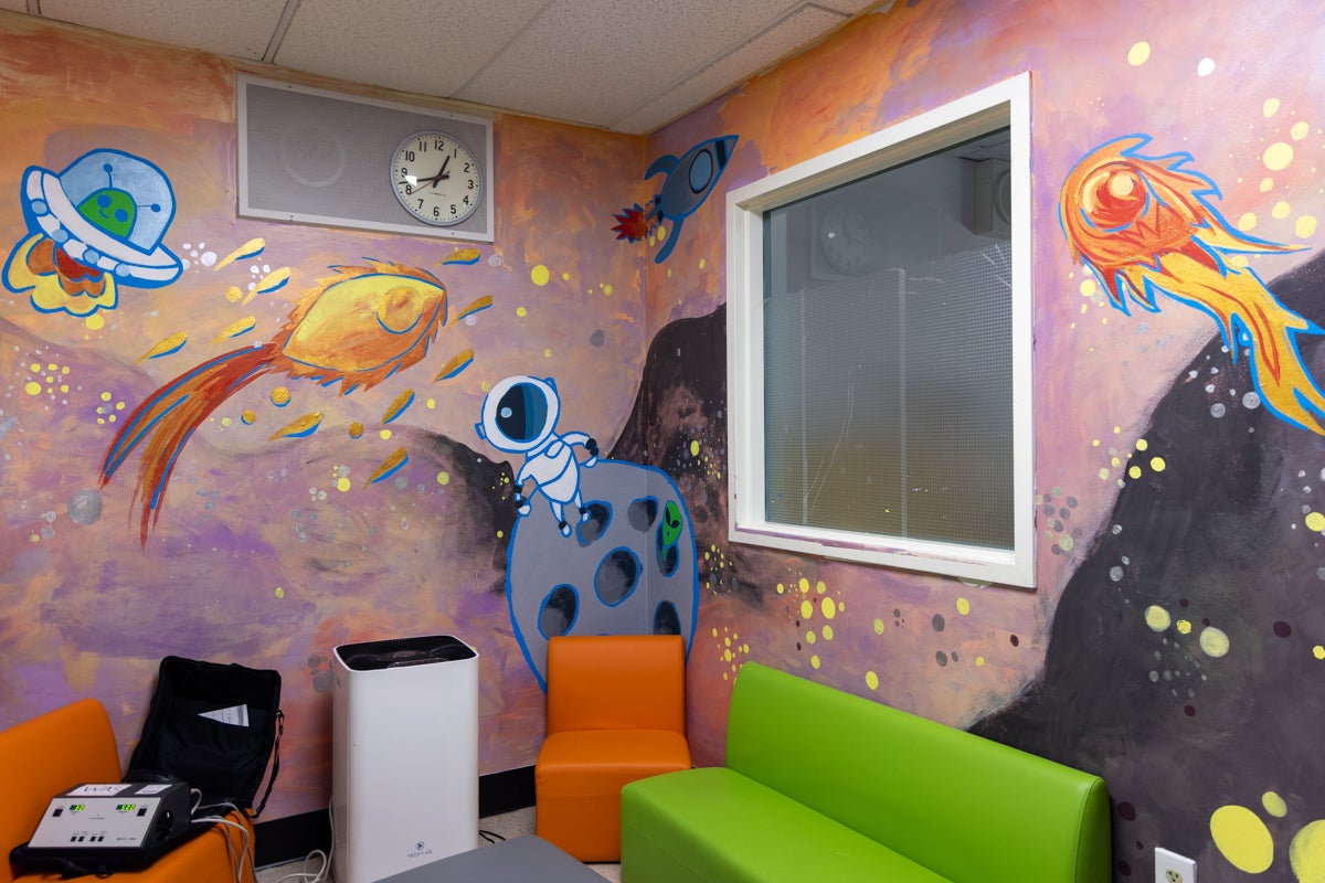 a mural of a person and alien in space