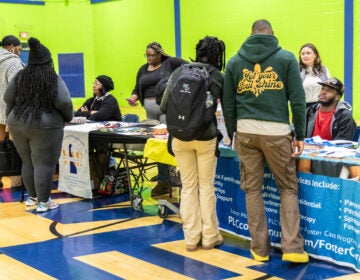 Attendees of the resource fair speak with vendors at their tables during the resource fair