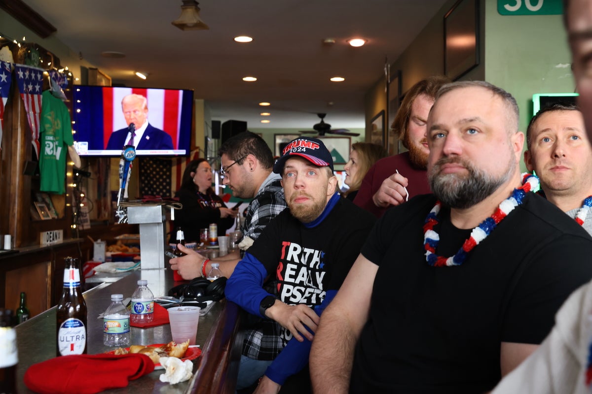 A group of Trump supporters watches President Trump's inauguration on January 20, 2025, at Dean’s Bar in South Philadelphia on televisions behind the bar. (Emma Lee/WHYY)