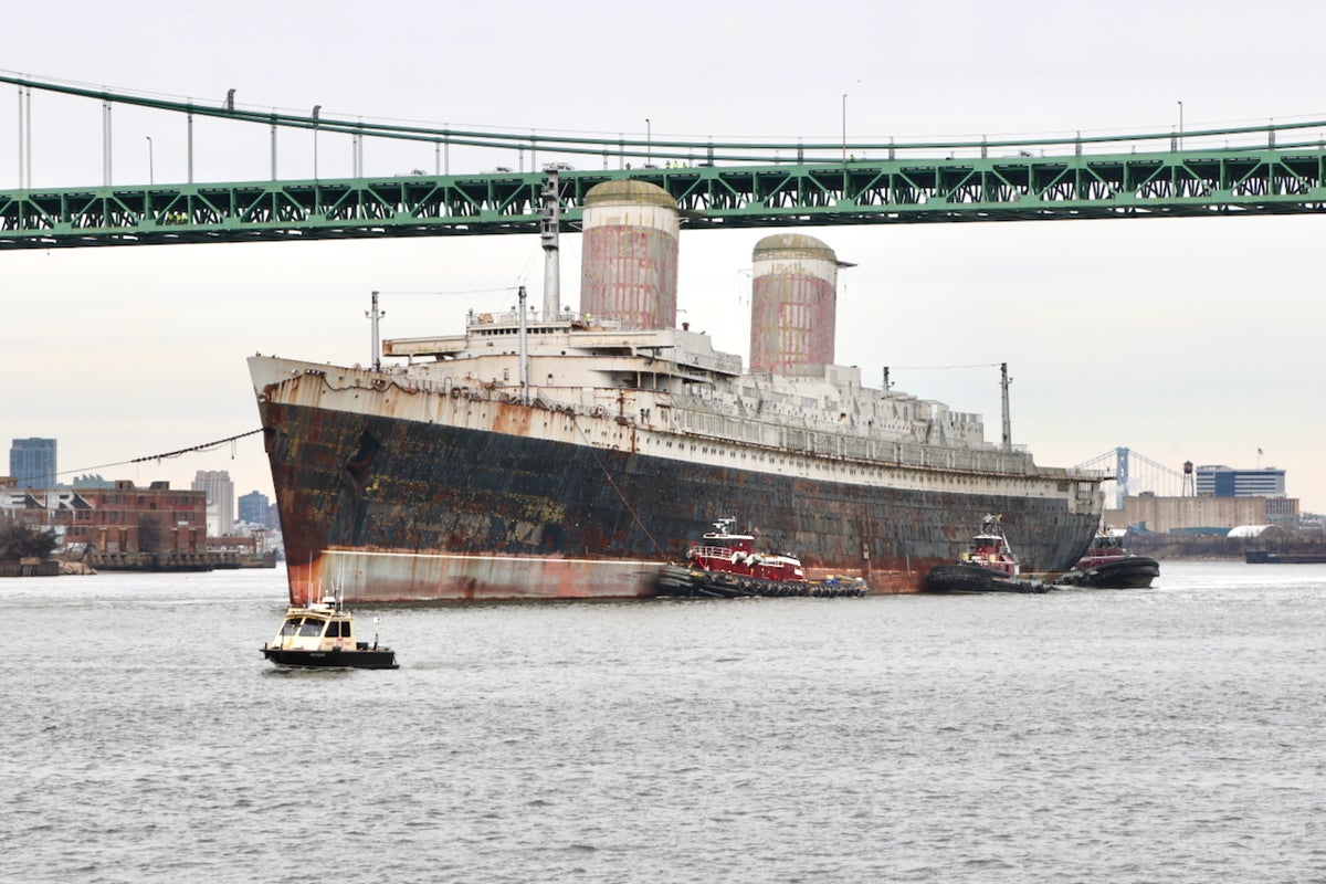 The S.S. United States, a 1,000-foot-long ocean liner, passes under the Walt Whitman Bridge on the Delaware River in Philadelphia on Feb. 19, 2025, on its journey to Florida.