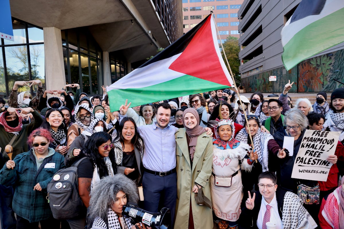 Palestinian activist Mahmoud Khalil poses for a large group photo with Palestinian flag-waving protesters outside the federal courthouse in Philadelphia.