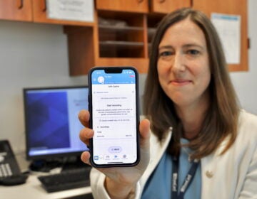 Corinne Rhodes holds up her phone