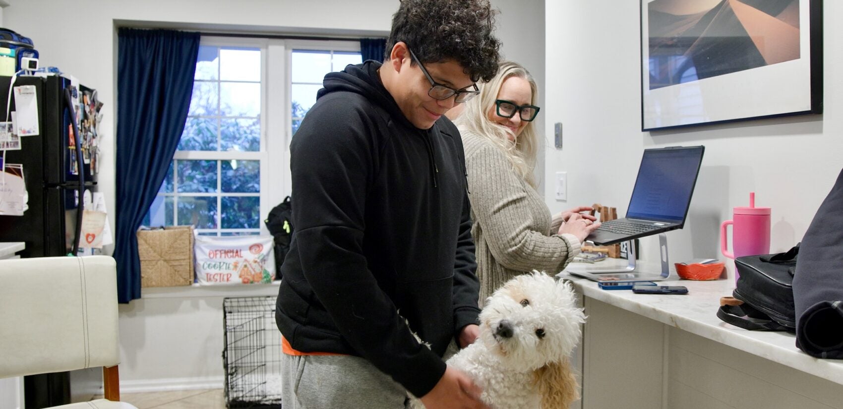 Derek McGlasson playing with a dog in his home
