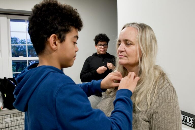 A child fixing his mother's necklace