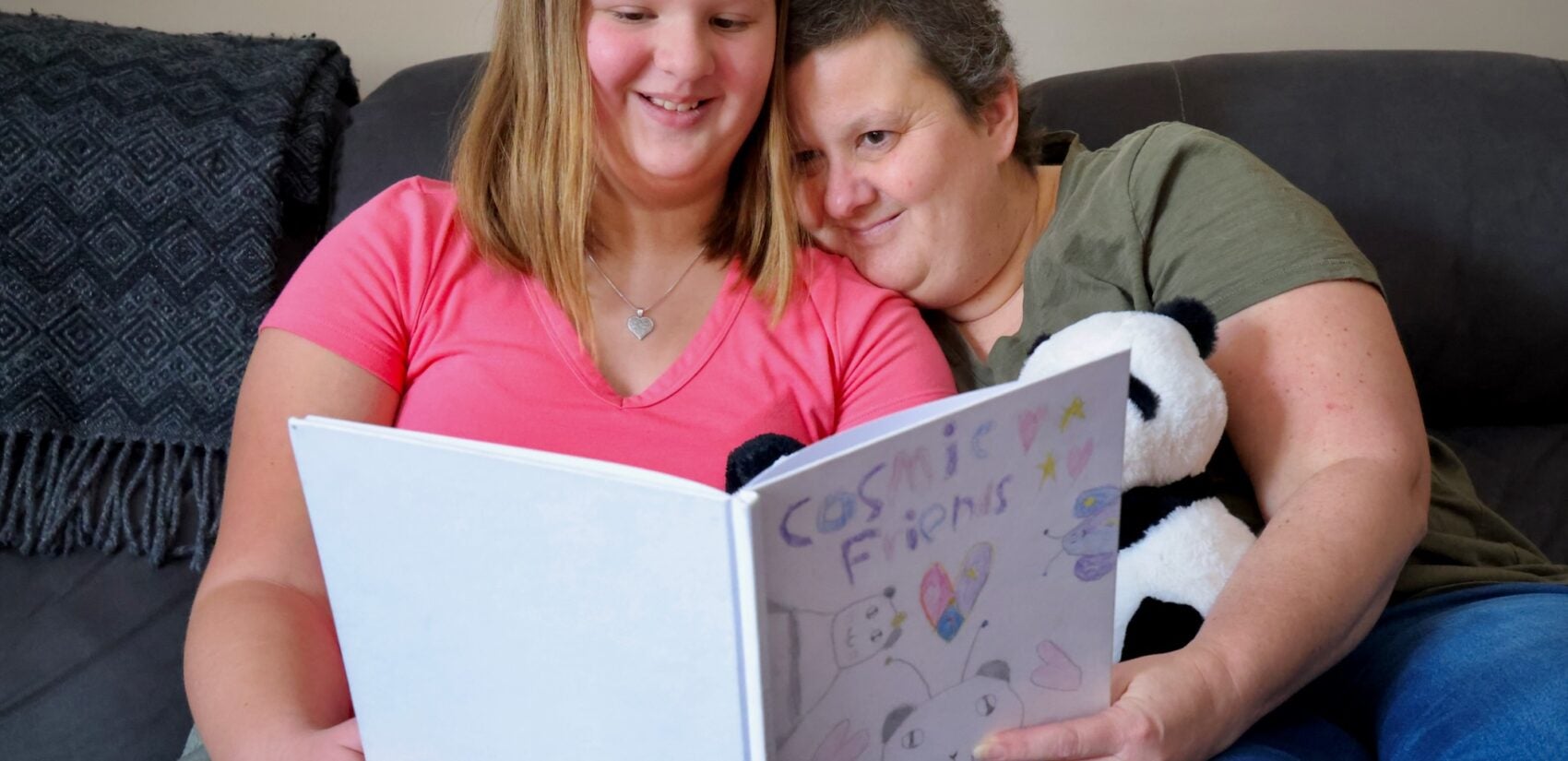 Lizzy Thomas, 10, and her mom, Yvonne, look through the book that Lizzy wrote and illustrated