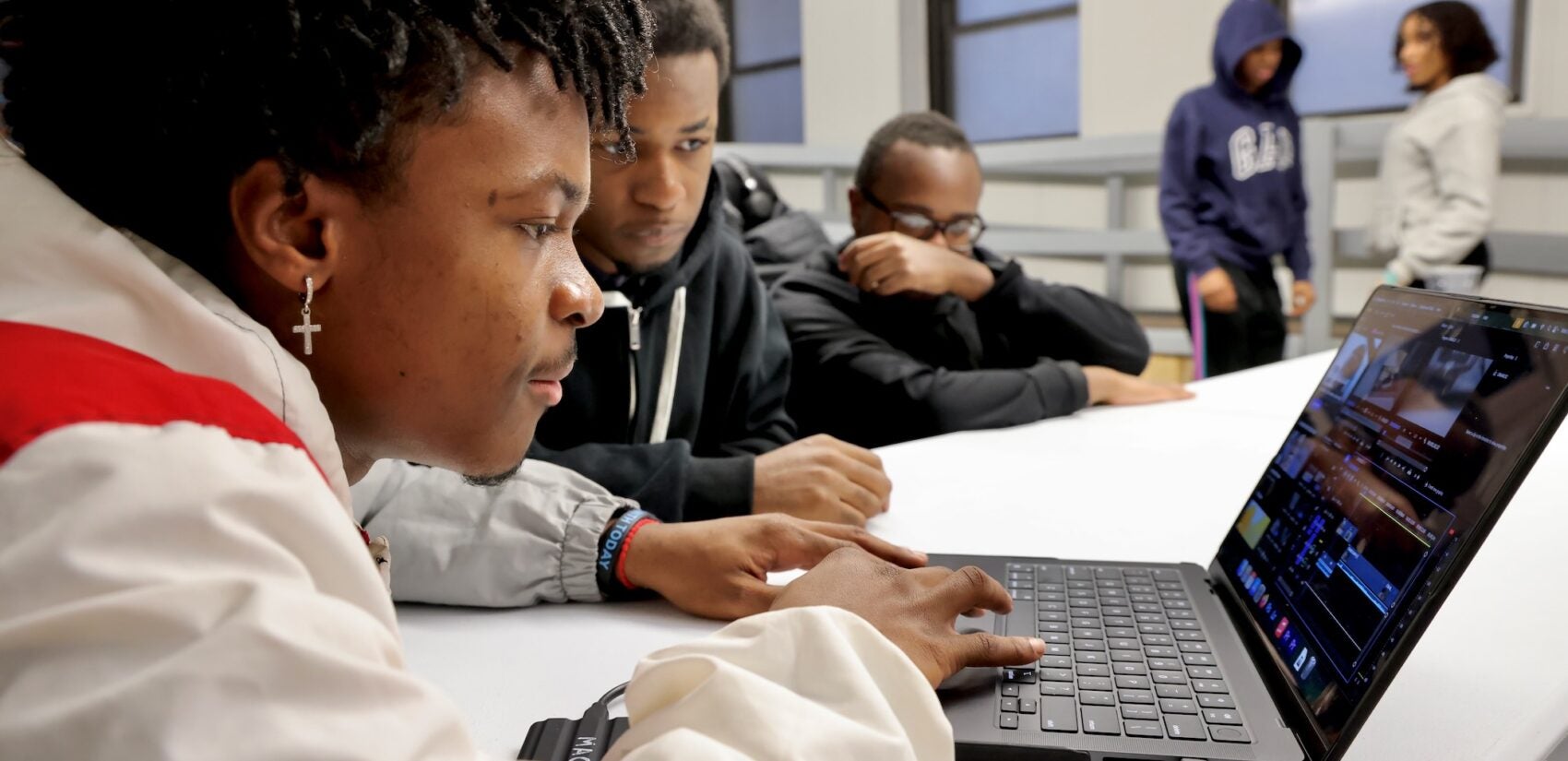 Overton Duhaney is in the. classroom, working on a laptop computer