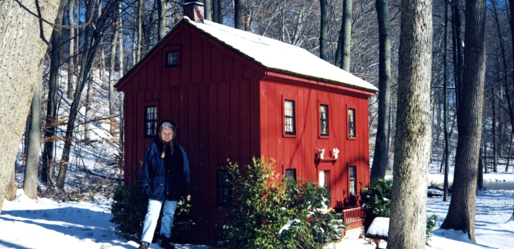 Ann Wyeth McCoy stands beside her dollhouse