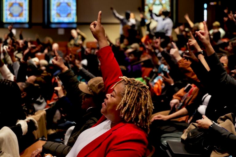 Members of the audience enthusiastically raise one finger in the air in response to Cherelle Parker's speech at Temple University
