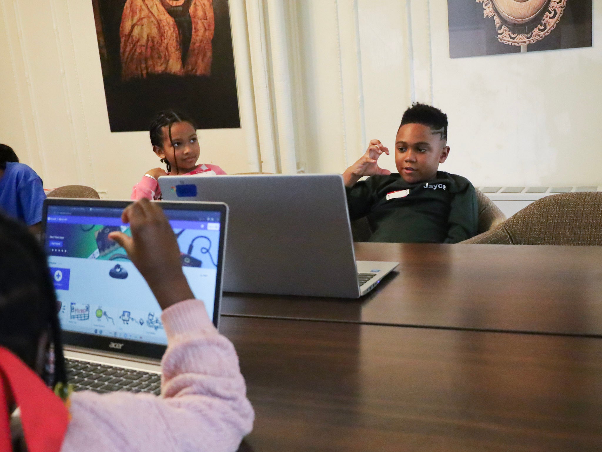 a child makes a hand pose in front of a webcam