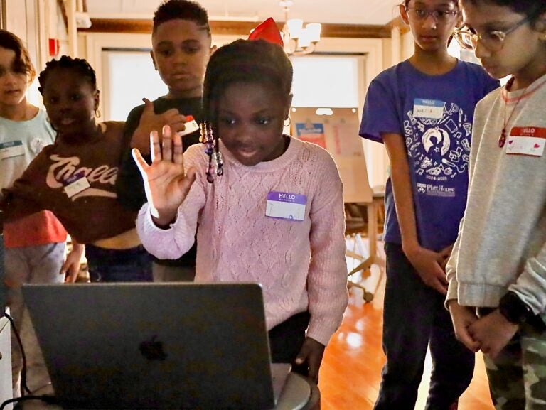 a child makes a hand pose in front of a webcam