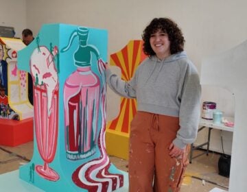 Roselyn Dooley stands next to her sculpture