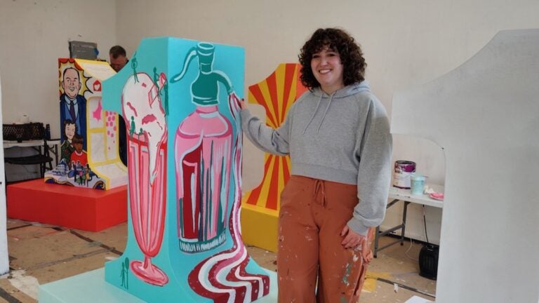 Roselyn Dooley stands next to her sculpture