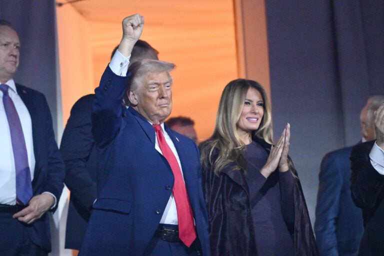 President Donald Trump pumps his fist alongside first lady Melania Trump