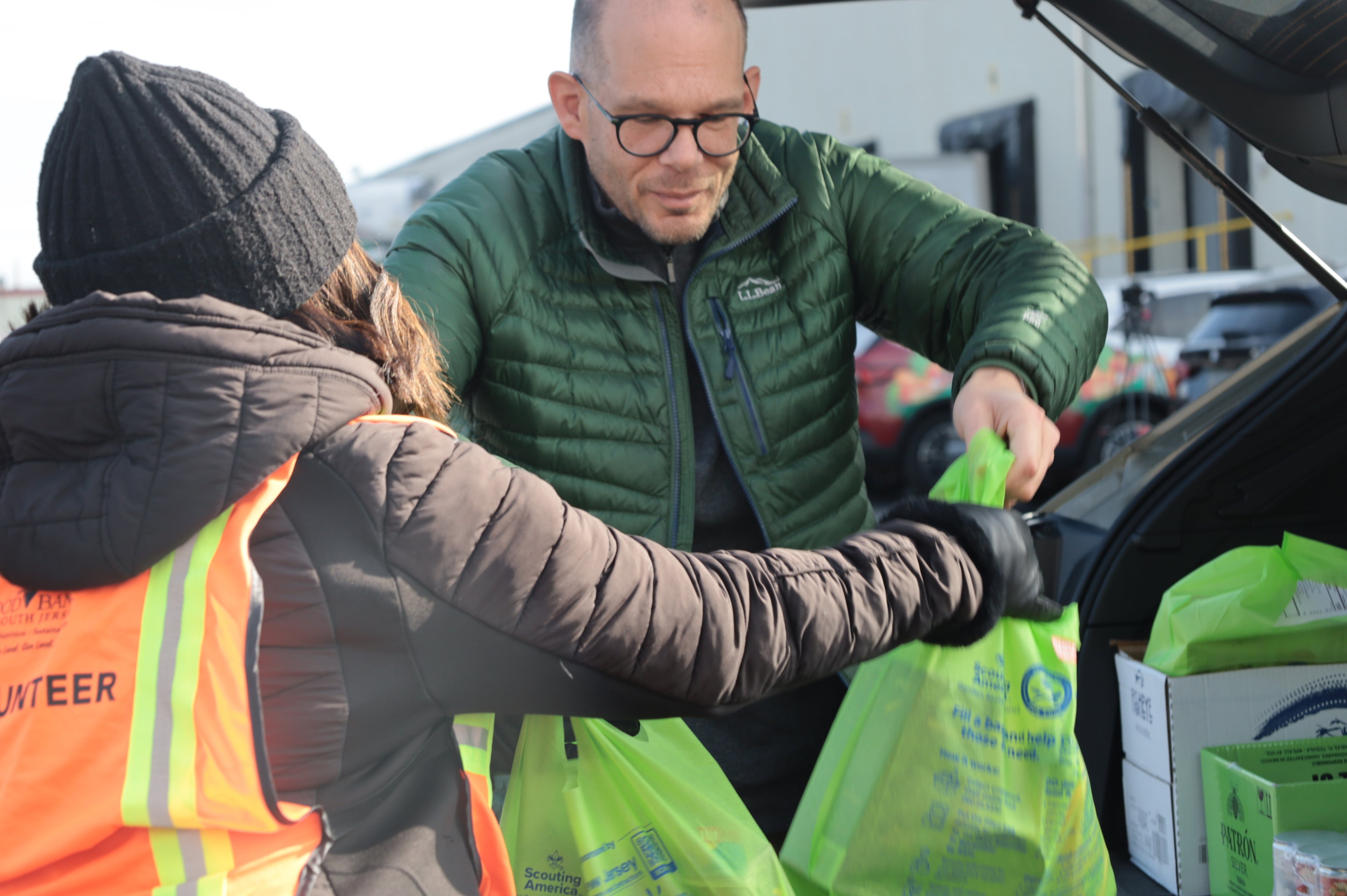 a volunteer helping put food in a car