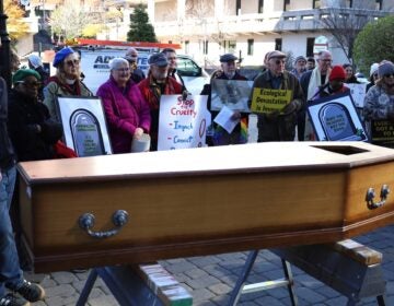 Los manifestantes se reúnen detrás de un ataúd de madera