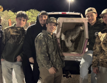 A group of people pose next to Rex the Wallaby