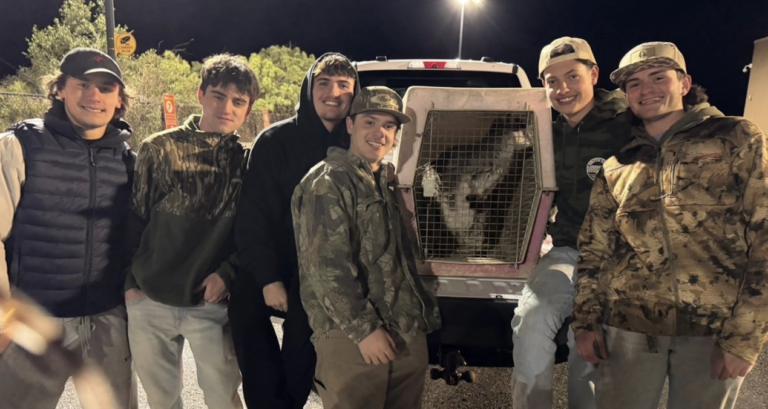 A group of people pose next to Rex the Wallaby