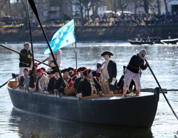 washington-crossing-reenactment copy People in a boat reenact General George Washington and his troops crossing the Delaware River during the American Revolution
