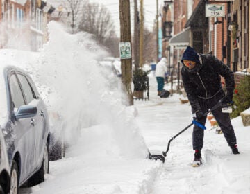 A resident uses a snowblower to clear the sidewalk in Philadelphia’s Fishtown neighborhood on Jan. 25, 2026.