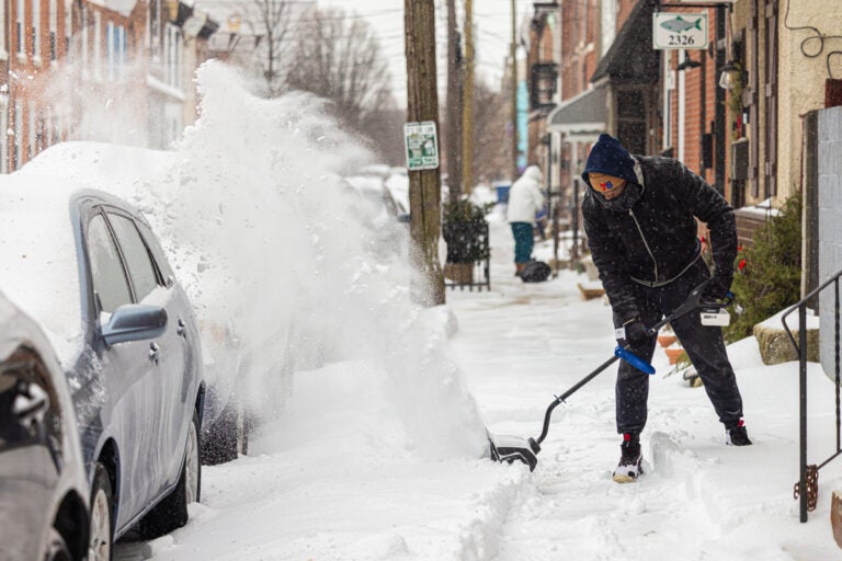 A resident uses a snowblower to clear the sidewalk in Philadelphia’s Fishtown neighborhood on Jan. 25, 2026.
