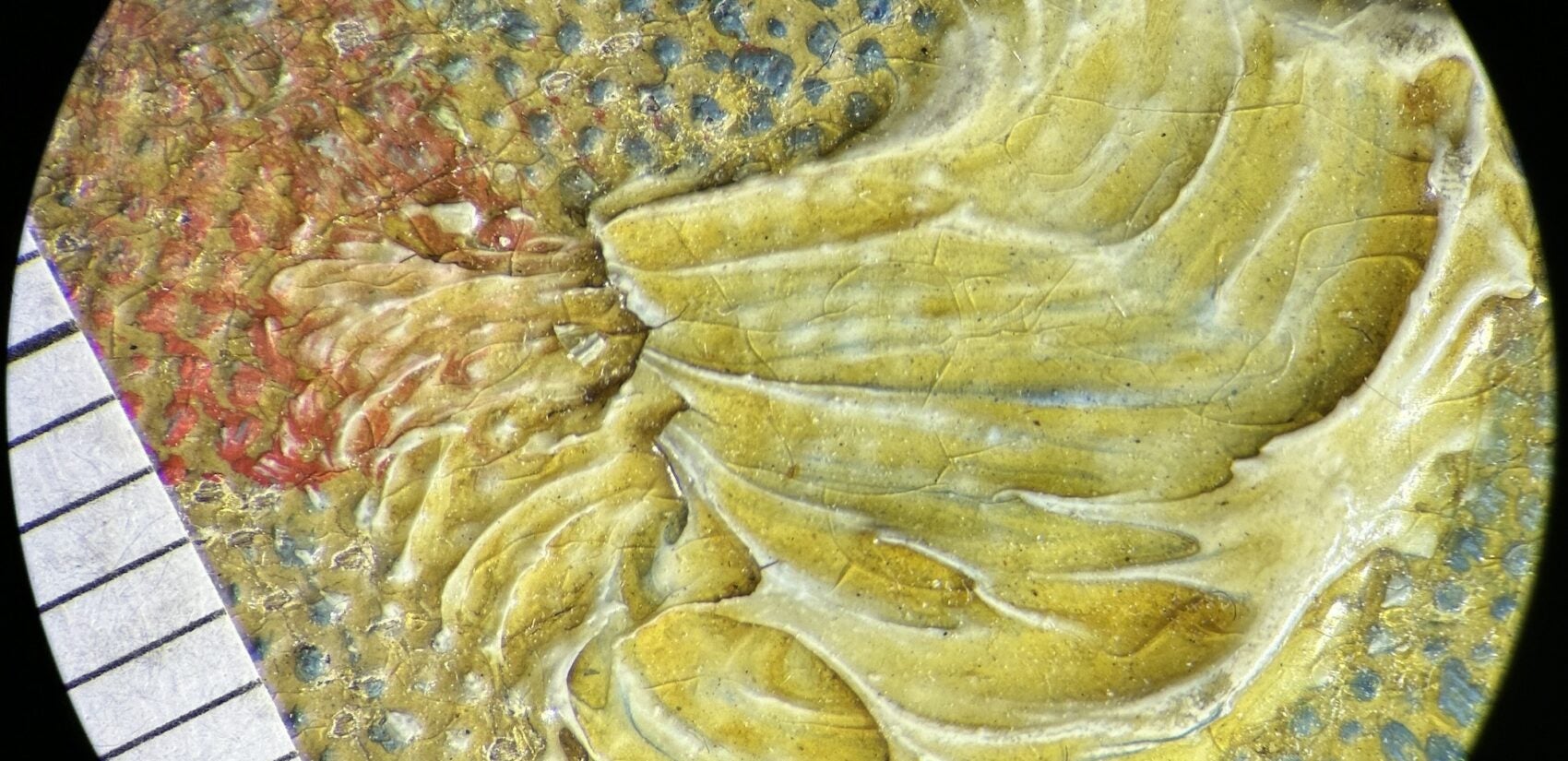 A microscopic view shows a painting covered by a layer of resin varnish that oxidized to yellow
