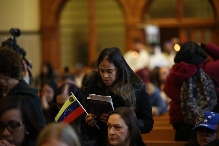 a person holds a Venezuelan flag at the Cathedral Basilica of Saints Peter and Paul