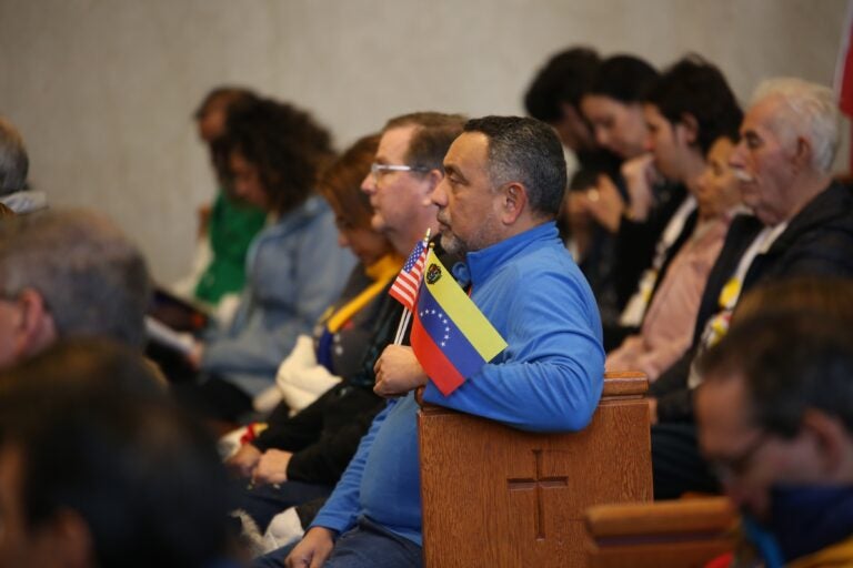 People hold Venezuelan flags at the Cathedral Basilica of Saints Peter and Paul