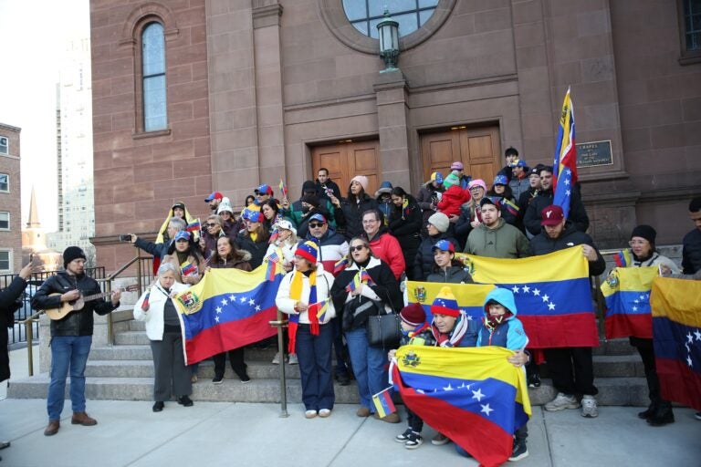 People hold Venezuelan flags outside the Cathedral Basilica of Saints Peter and Paul