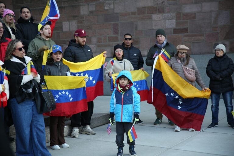 People hold Venezuelan flags outside the Cathedral Basilica of Saints Peter and Paul